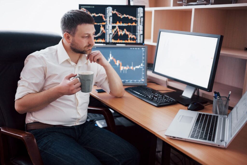 Man working on computer with many monitors and diagrams on it